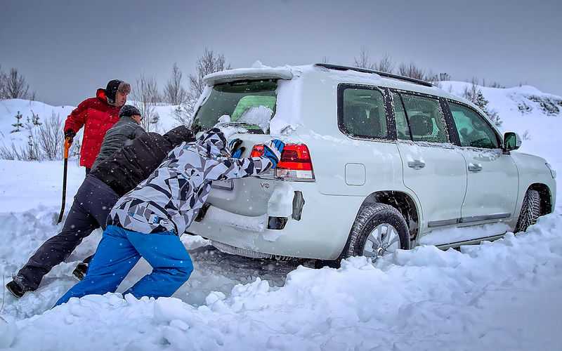 Девушки толкают застрявший автомобиль